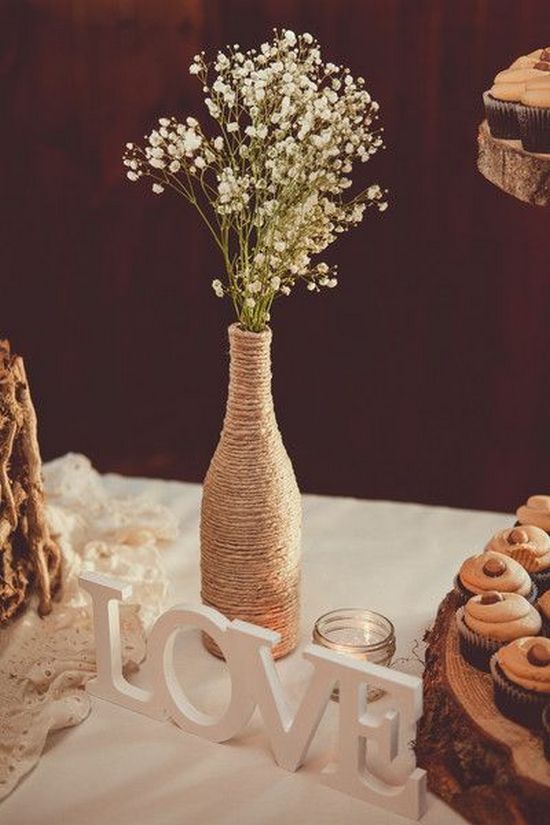 Rustic wedding centerpiece idea – wine bottles wrapped in twine and filled with baby’s breath