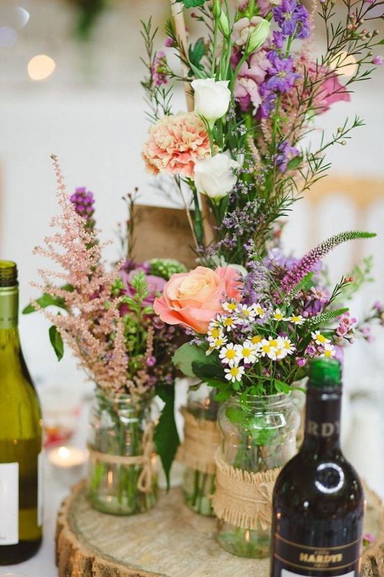 rustic table centre pieces using roses and wild flowers, recycled jam jars and hessian