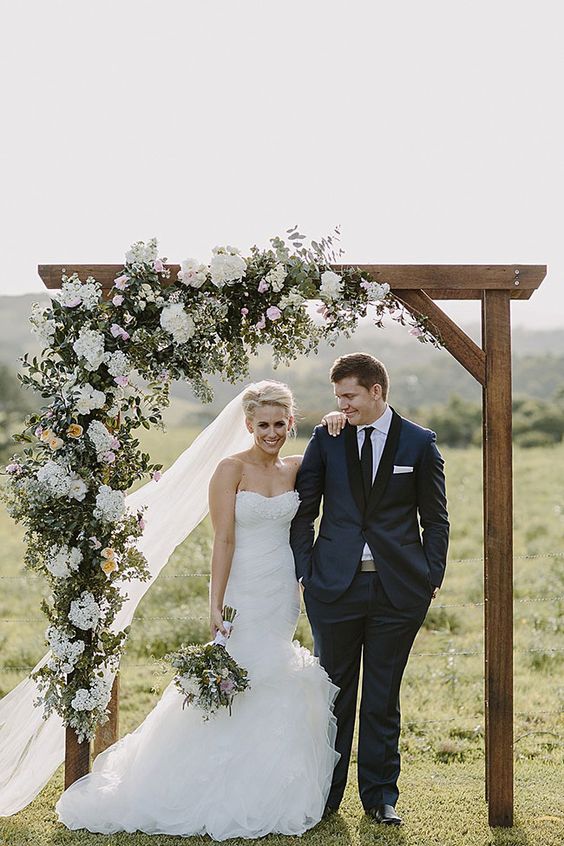 Stunning wedding arch with cascading floral arrangement in a neutral palette