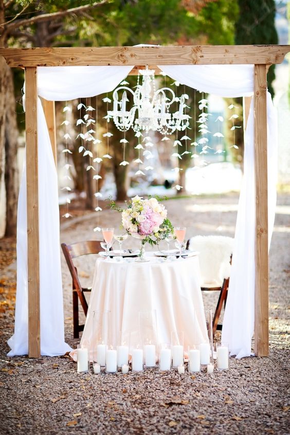 Sweetheart table under an arch with a chandelier