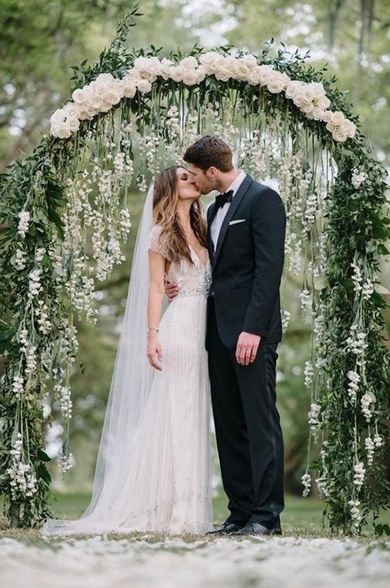 Stunning wedding arch with cascading floral arrangement in a neutral palette
