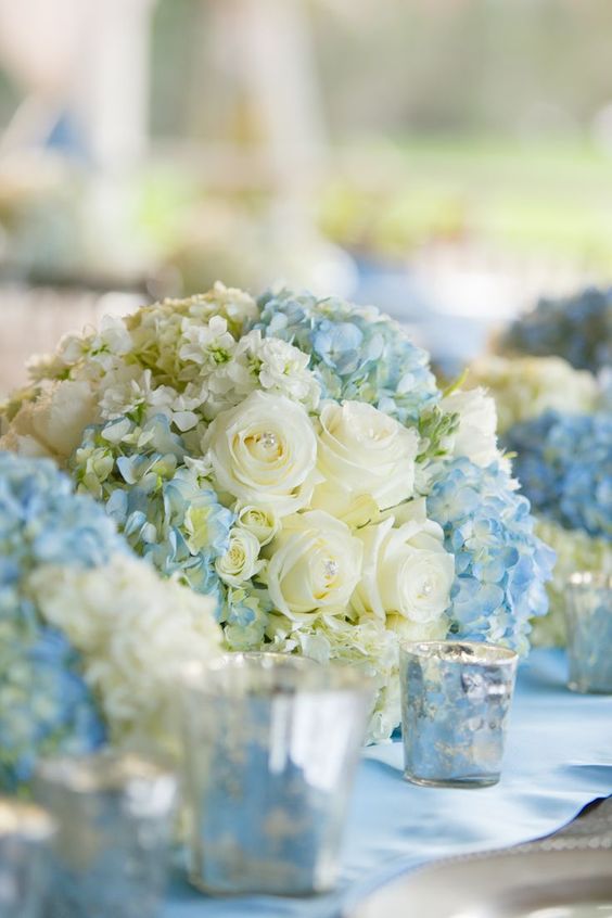 Pretty spring wedding centerpieces with white roses and light blue hydrangeas