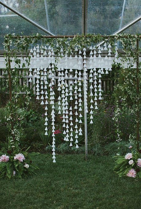 whimsical DIY ceremony altar wrapped in wild vines with hanging cone garlands