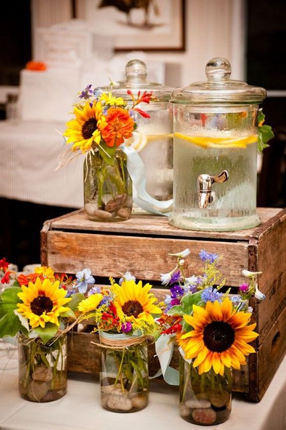 single stem of sunflower create a beautiful line of pew markers for this outdoor country wedding