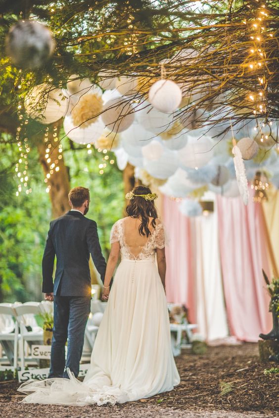Decorated with pom pons, twinkling fairy lights and satin fabric backdrop for couple