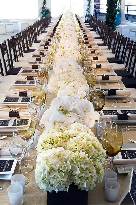 long rows of all white arrangements of hydrangeas and orchids