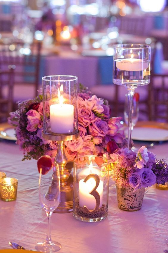 purple floral wedding reception centerpiece with divine candles