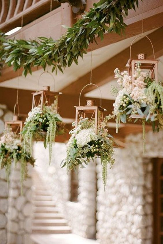 copper lanterns overflowing with a variety of greens wedding decor