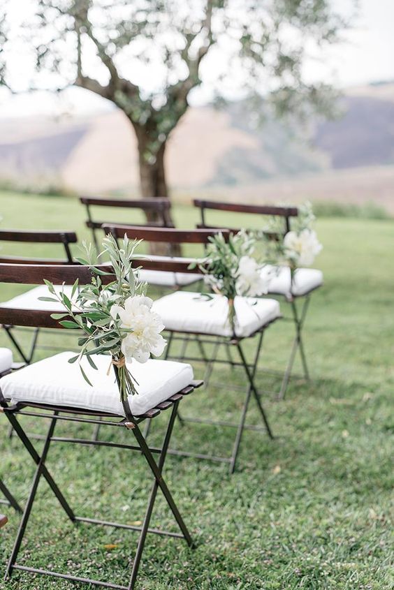 elegant ceremony aisle markers made of white peonies and olive branches