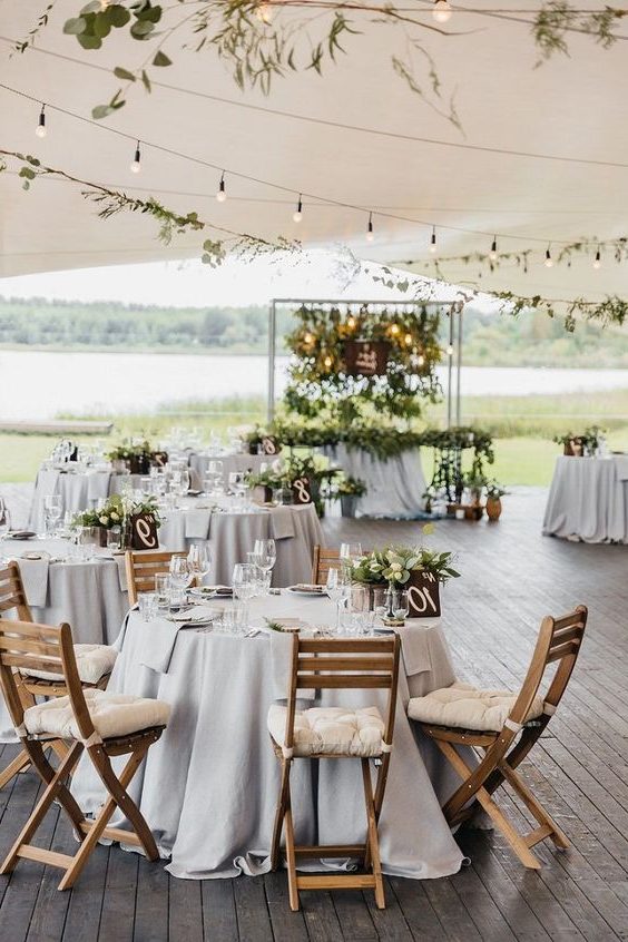 tented wedding reception with wood flooring, gray linens