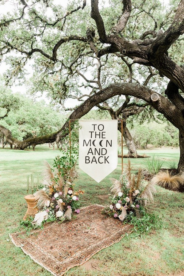 ceremony arch features macrame + white flowers and greenery for a boho feel