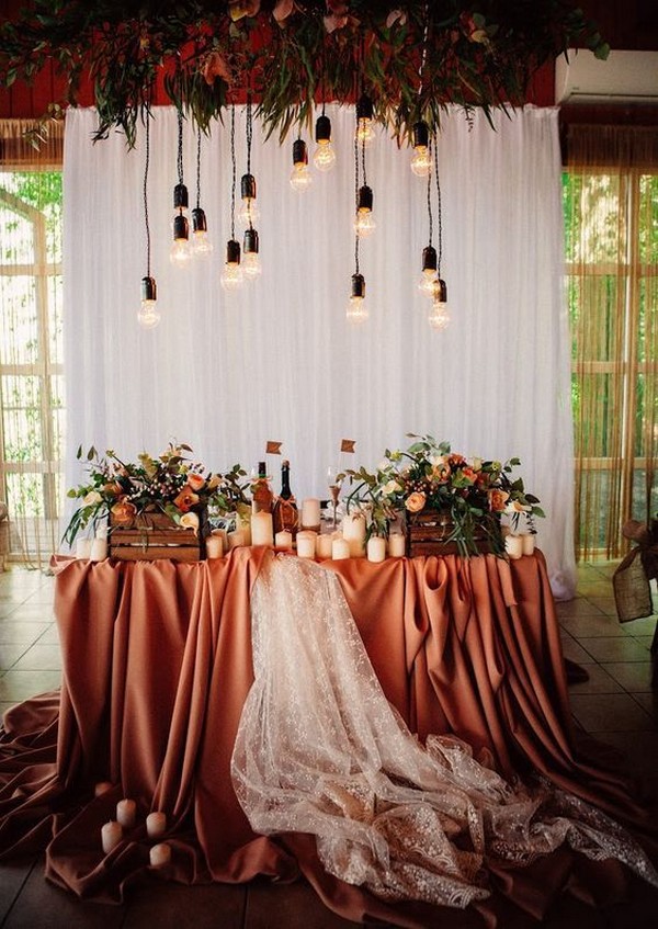 white curtain backdrop overhead blooms and bulbs for a fall wedding