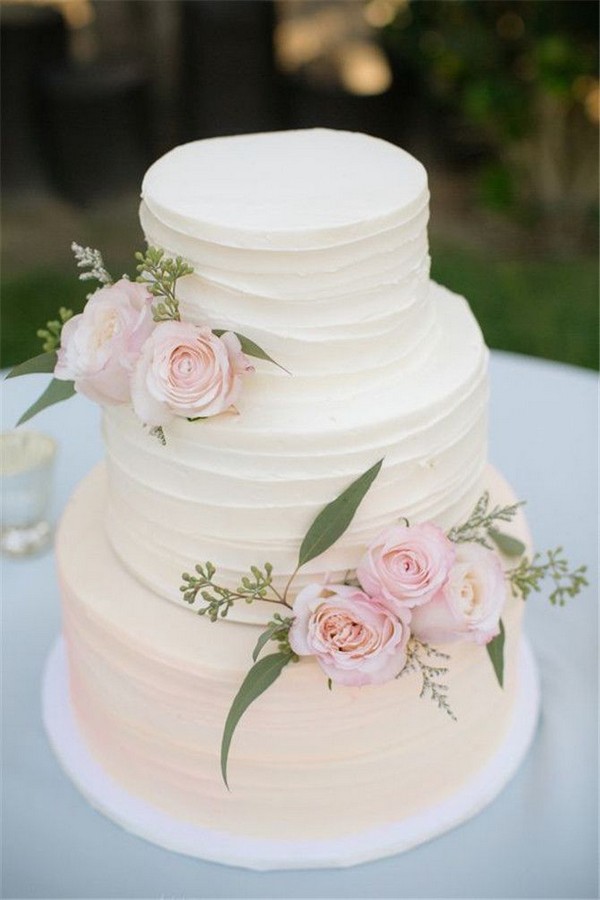 Simple wedding cake with pink roses and seeded eucalyptus