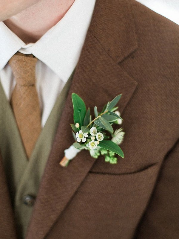 White and green boutonniere on brown and green suit
