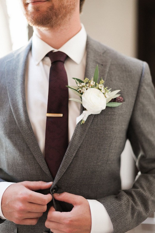 grey fall and winter groom wedding suit and burgundy tie and white boutonniere