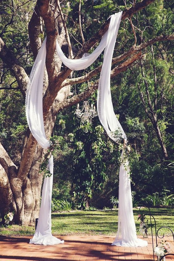 outdoor wedding arch ideas with drapery hung on a tree