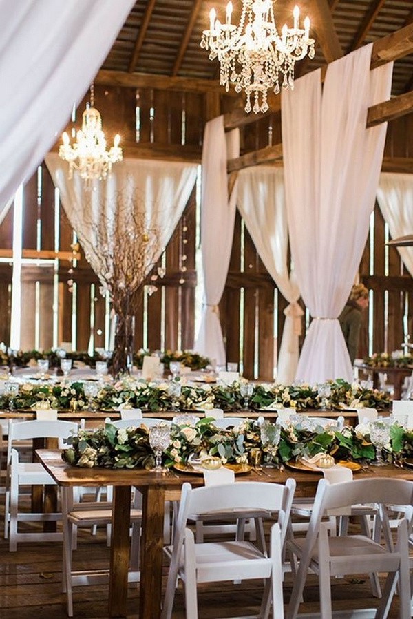 rustic barn wedding reception with greenery on wooden table