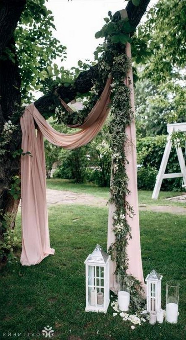 simple pink and green tree wedding backdrop with lanterns