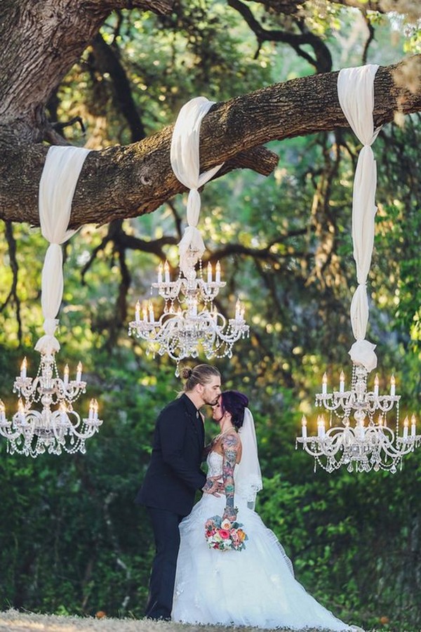 unique wedding backdrop with chandeliers hung on a tree