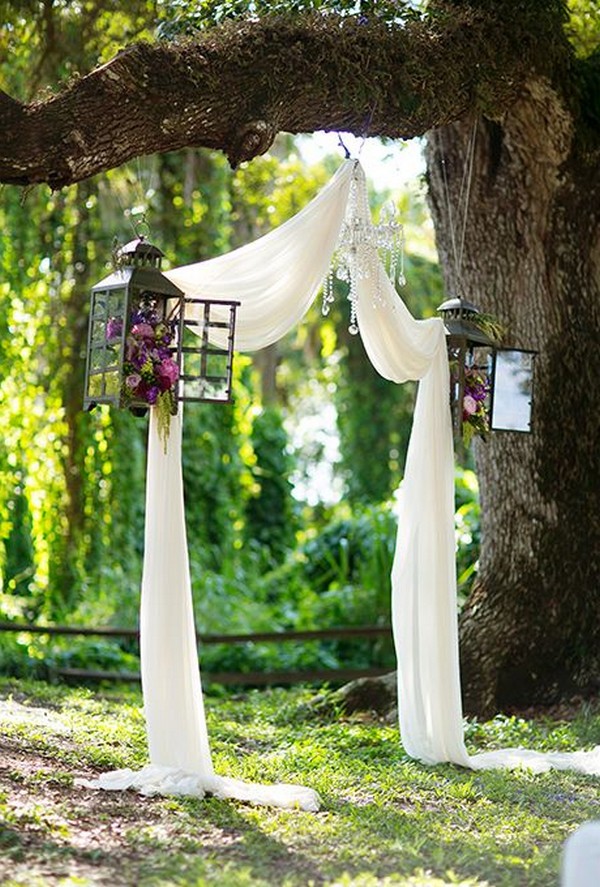 wedding altar ideas with drapery and lanterns hung on a tree